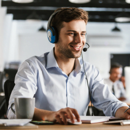 Smiling man talking with clinet in customer support centre