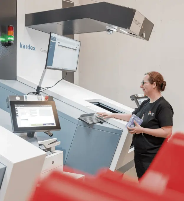 Women in SMS Fulfillment warehouse operating pick and pack machine